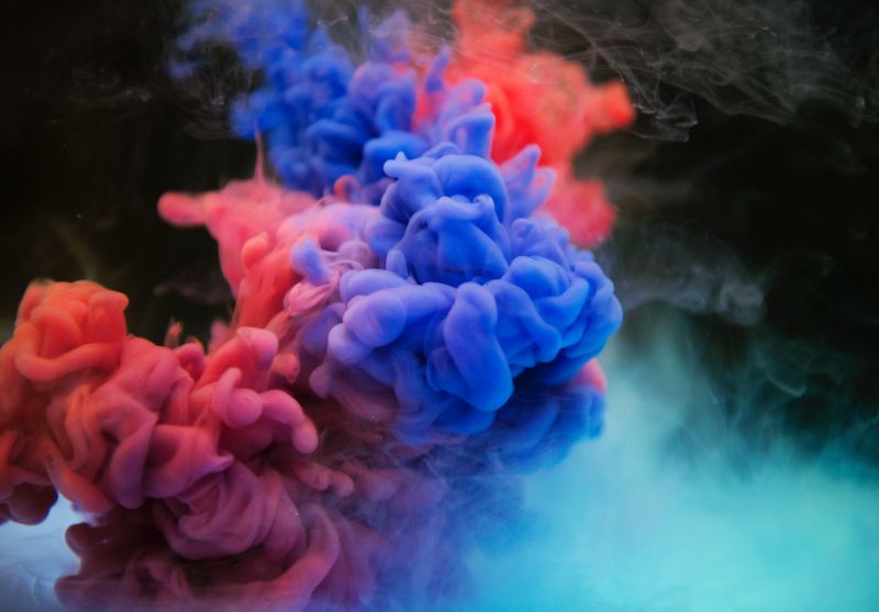 Abstract photograph of red and blue smoke on a black background